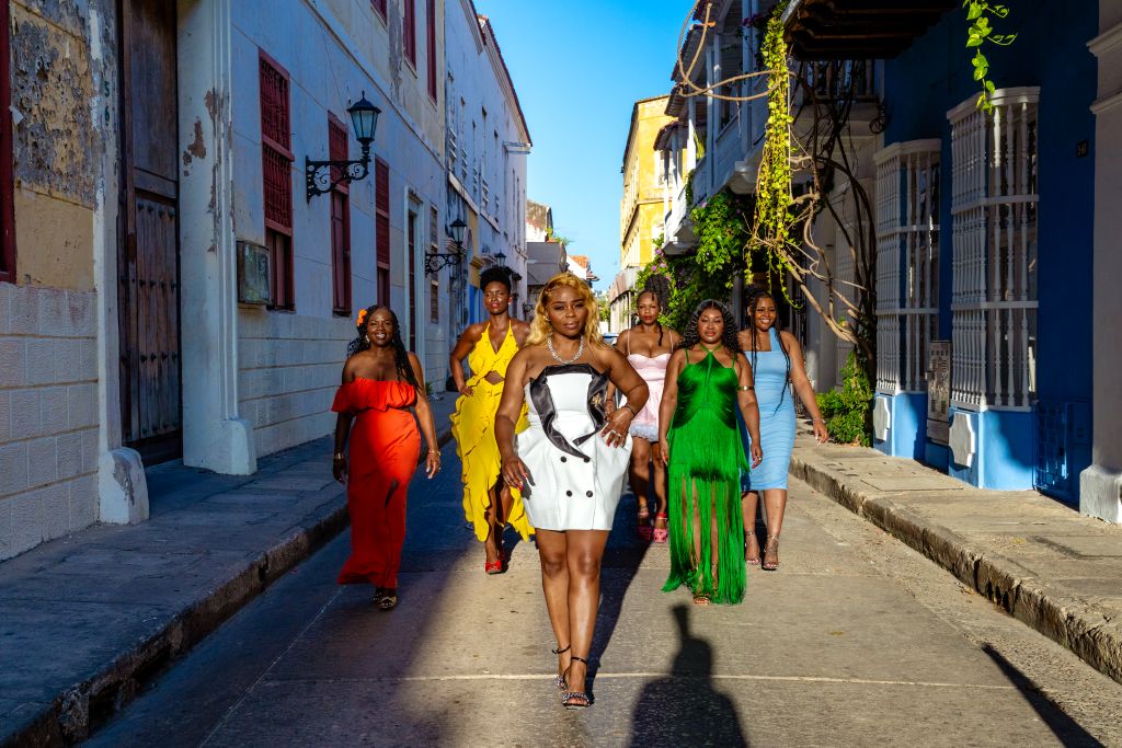 Group photo session in Cartagena with travelers wearing bright and colorful outfits that match the city’s vibrant atmosphere