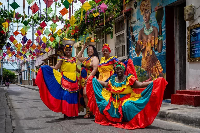 A Black female solo traveler in candid photo session in Getsemani with palenquera ladies